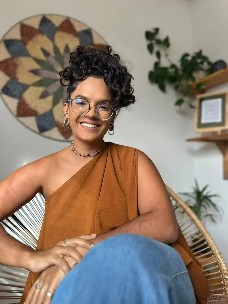 Vitória sorrindo, sentada numa poltrona de fibra